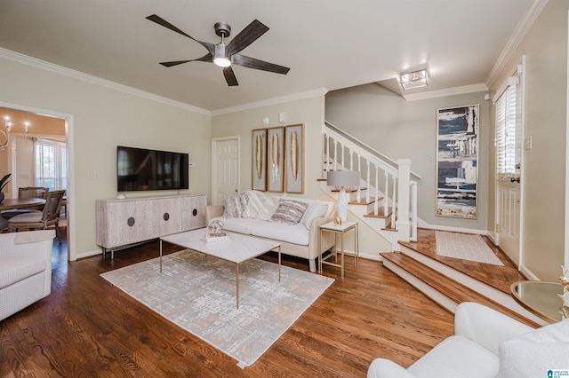 living area with crown molding, ceiling fan, wood finished floors, and stairs