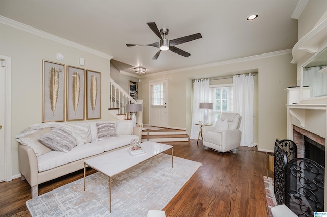 living room featuring baseboards, crown molding, stairs, ceiling fan, and wood finished floors