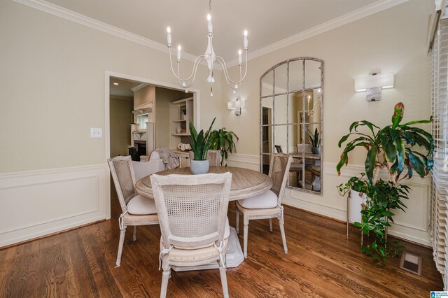 dining room with ornamental molding, visible vents, wainscoting, and wood finished floors
