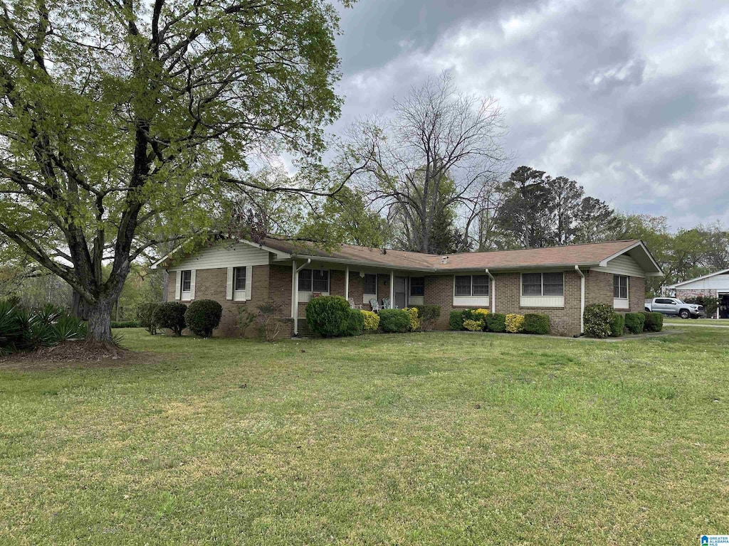 ranch-style house featuring brick siding and a front lawn