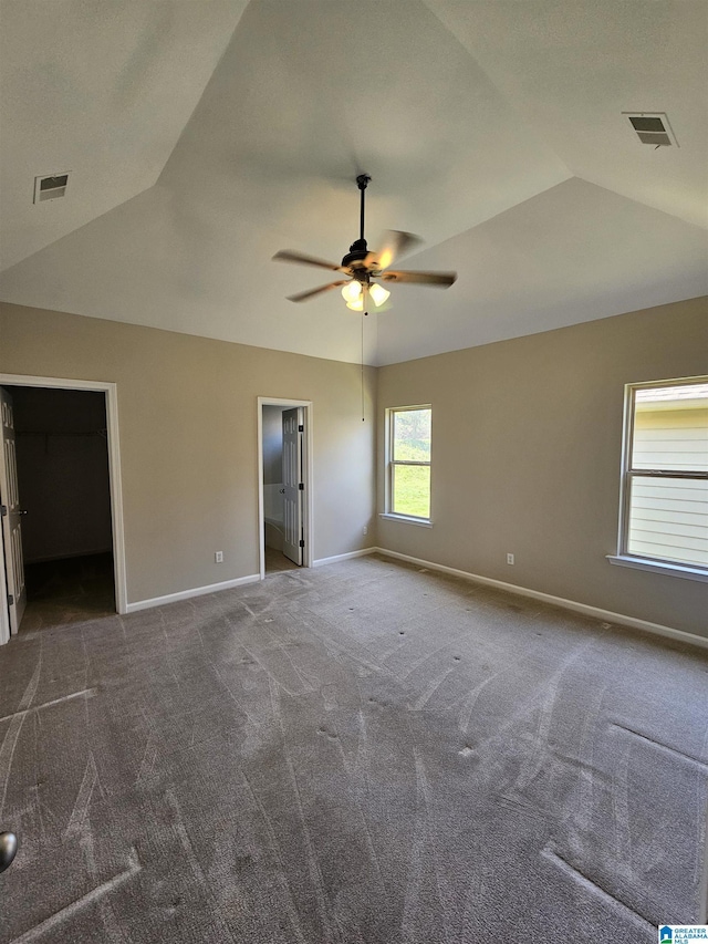 unfurnished bedroom featuring visible vents, baseboards, and lofted ceiling
