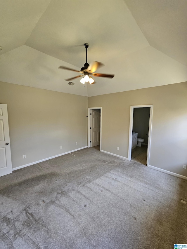 unfurnished bedroom featuring visible vents, baseboards, carpet flooring, and vaulted ceiling