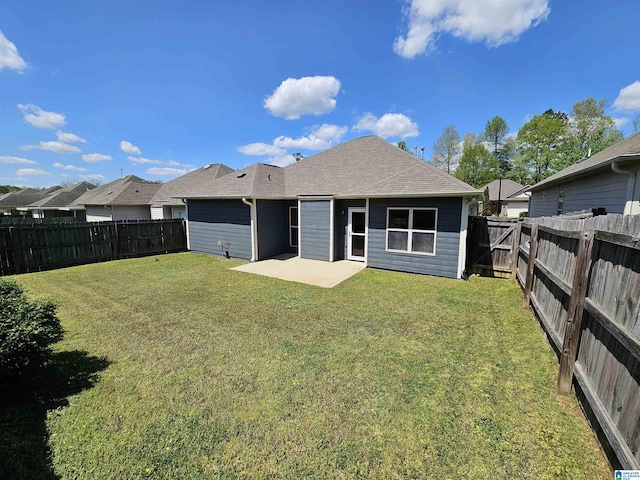 rear view of property with a yard, a fenced backyard, roof with shingles, and a patio area