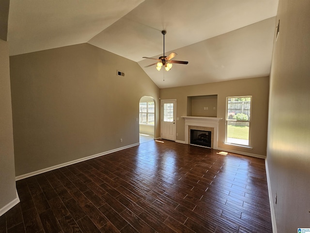 unfurnished living room featuring dark wood finished floors, a tiled fireplace, vaulted ceiling, and ceiling fan