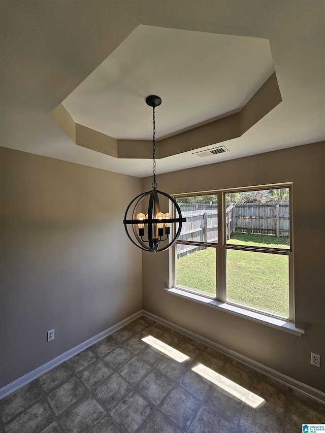 unfurnished dining area with a notable chandelier, visible vents, baseboards, and a raised ceiling