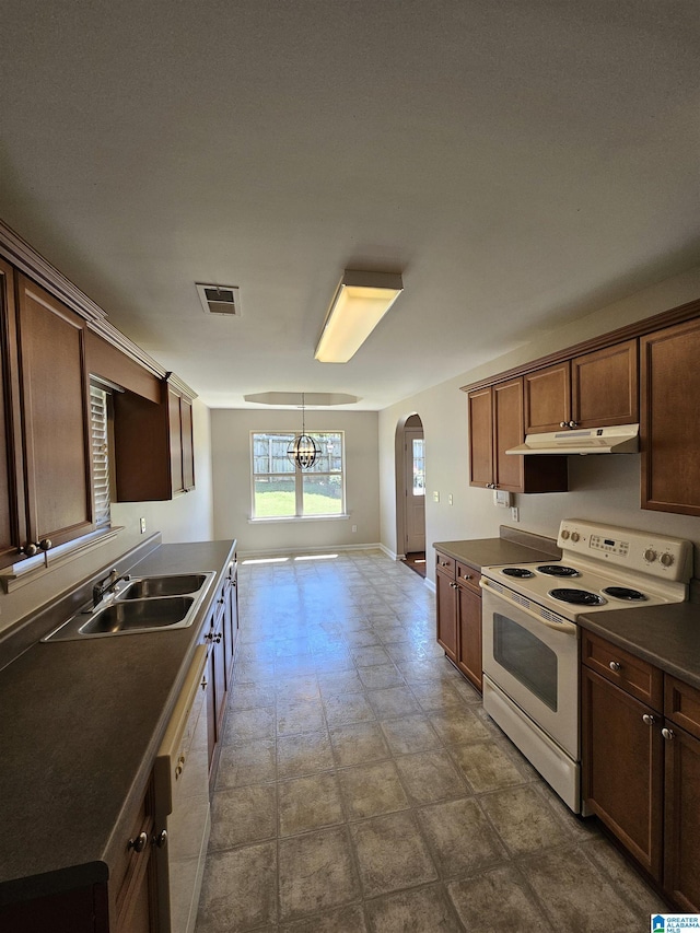 kitchen featuring visible vents, arched walkways, a sink, white appliances, and under cabinet range hood