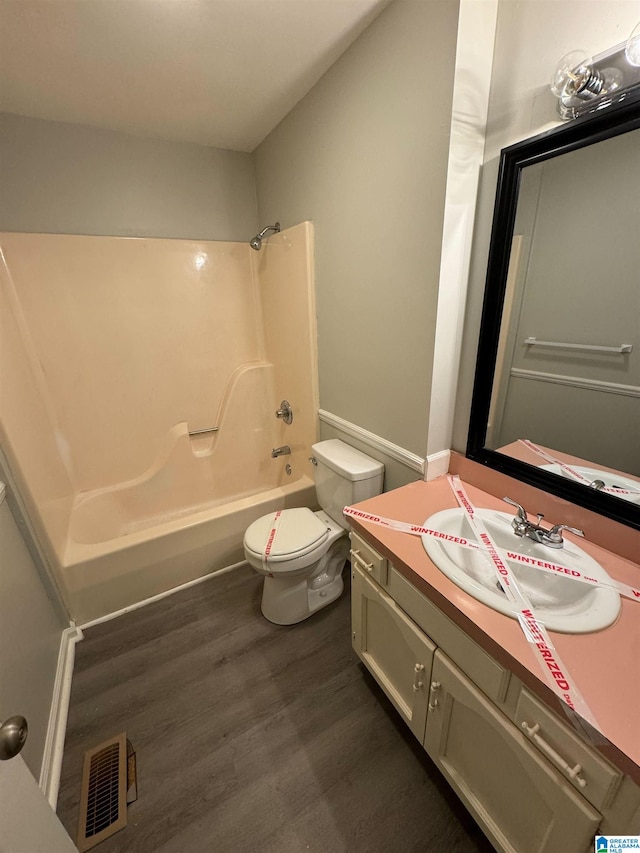 bathroom with visible vents, washtub / shower combination, toilet, vanity, and wood finished floors
