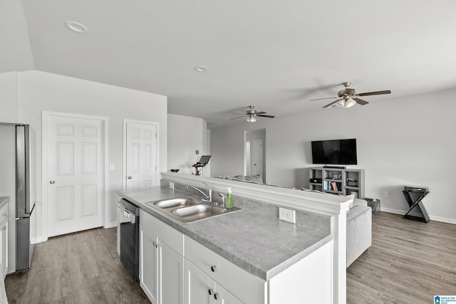 kitchen featuring white cabinets, wood finished floors, a sink, and appliances with stainless steel finishes