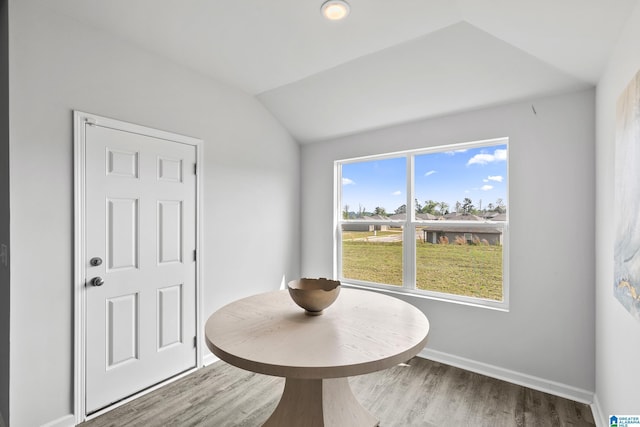 dining room with lofted ceiling, baseboards, and wood finished floors