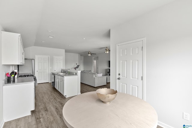 dining room with baseboards, a ceiling fan, wood finished floors, and lofted ceiling