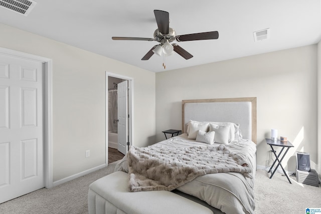 carpeted bedroom featuring baseboards, a ceiling fan, visible vents, and connected bathroom
