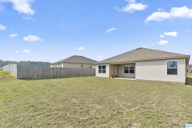rear view of property featuring fence, a yard, and a patio