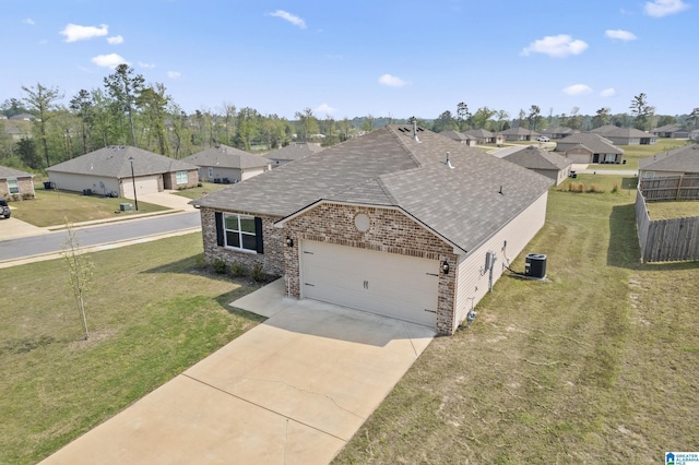 view of front of home with an attached garage, a residential view, a shingled roof, and central AC