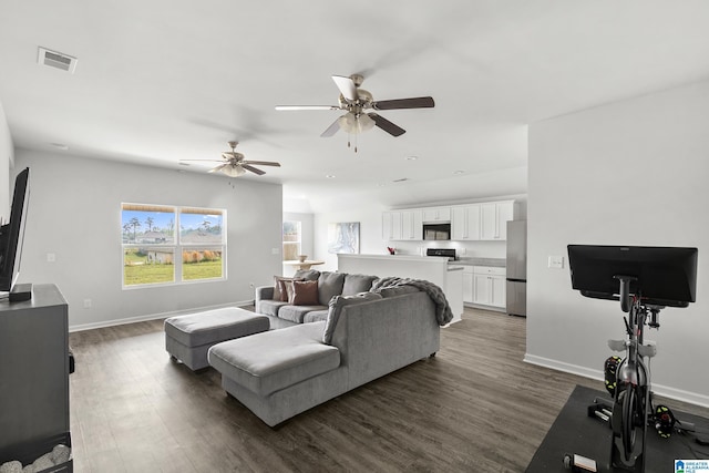 living room with dark wood-type flooring, visible vents, baseboards, and ceiling fan