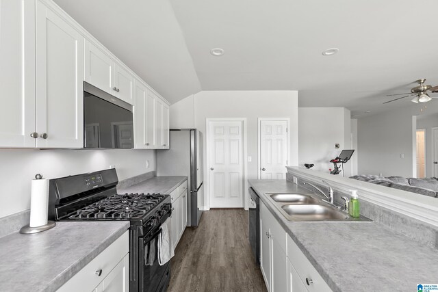kitchen with stainless steel appliances, a ceiling fan, a sink, open floor plan, and white cabinetry