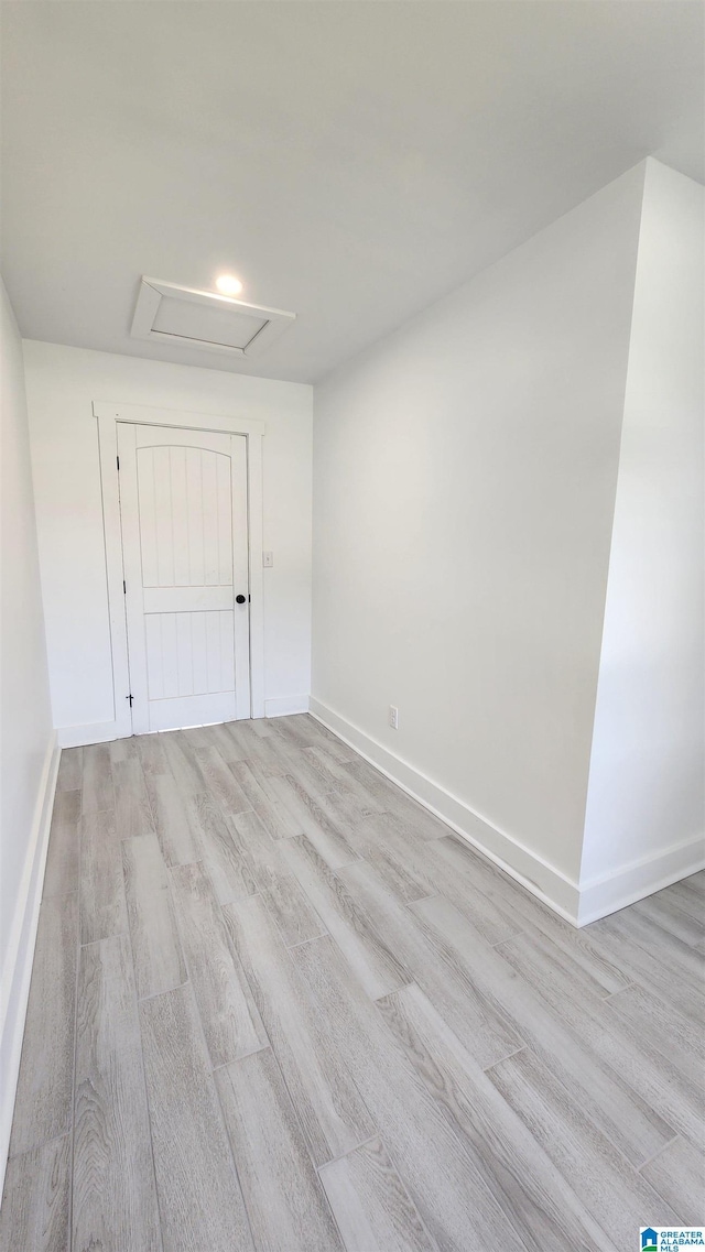 spare room featuring baseboards and light wood-type flooring