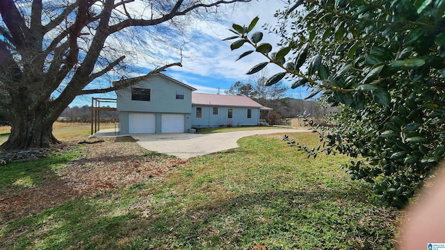 exterior space featuring a yard, a garage, and driveway