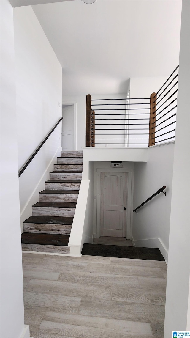 staircase featuring baseboards and wood finished floors