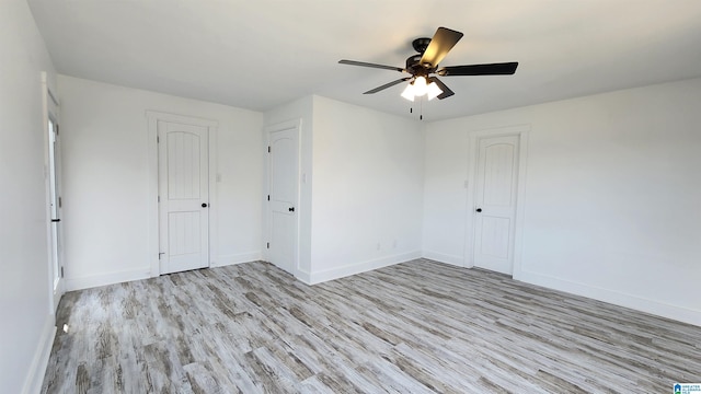 unfurnished room with baseboards, ceiling fan, and wood finished floors