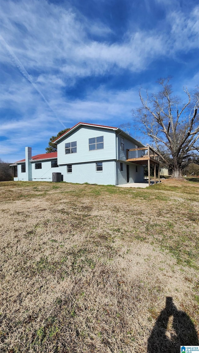 view of side of property with a yard and a wooden deck