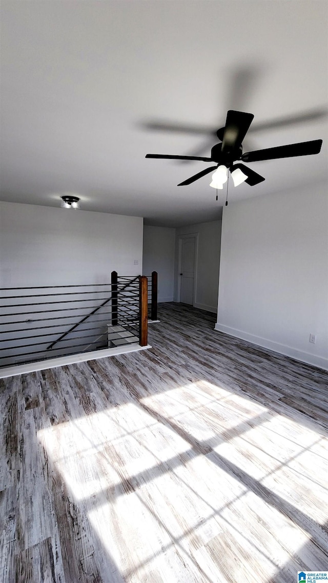 interior space featuring baseboards, a ceiling fan, and wood finished floors