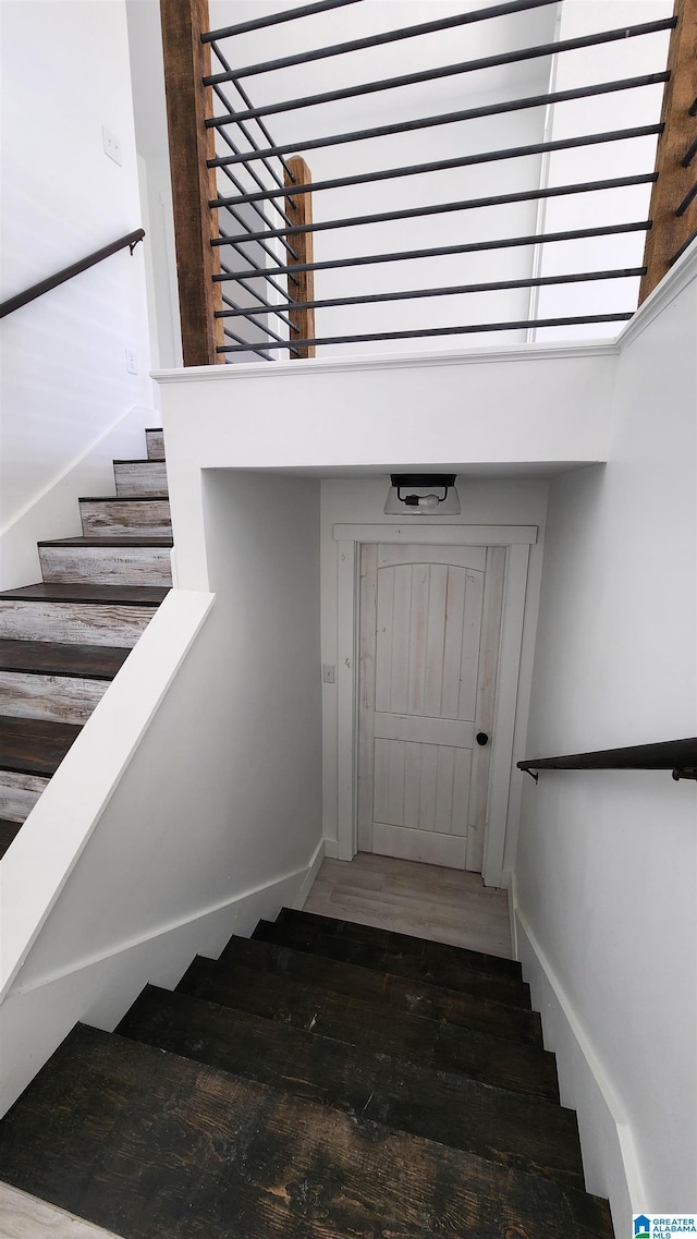stairway featuring baseboards and wood finished floors
