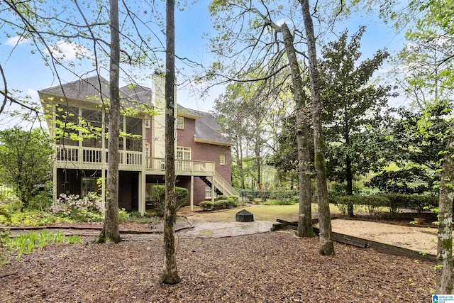 5006 Aberdeen Way, Hoover, AL 35242 - rear view of house with a wooden deck, a sunroom, an outdoor fire pit, roof with shingles, and stairs