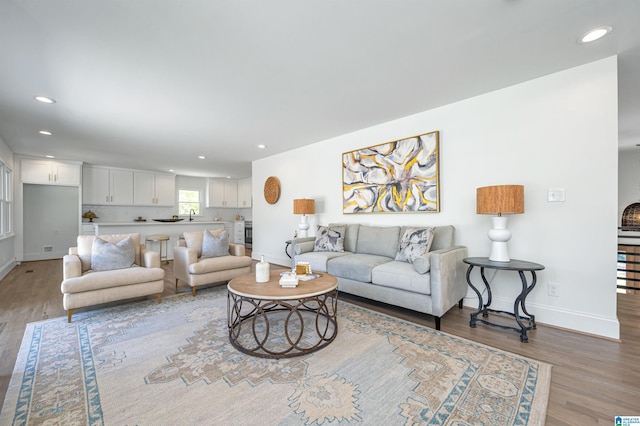 living area featuring recessed lighting, light wood-style floors, and baseboards