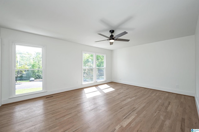 empty room with light wood-style flooring, baseboards, and ceiling fan
