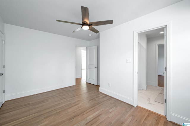 unfurnished bedroom featuring ceiling fan, light wood finished floors, and baseboards