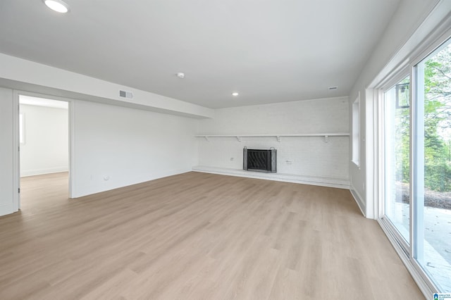 unfurnished living room with light wood-style flooring, a brick fireplace, visible vents, and recessed lighting
