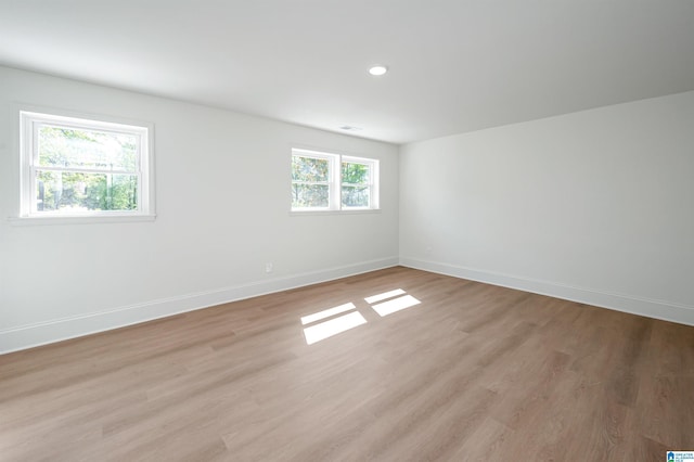 empty room featuring visible vents, baseboards, light wood finished floors, and recessed lighting