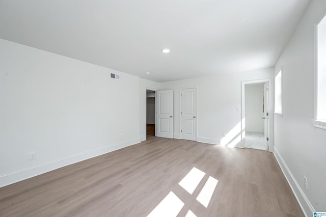 interior space featuring visible vents, baseboards, and light wood finished floors