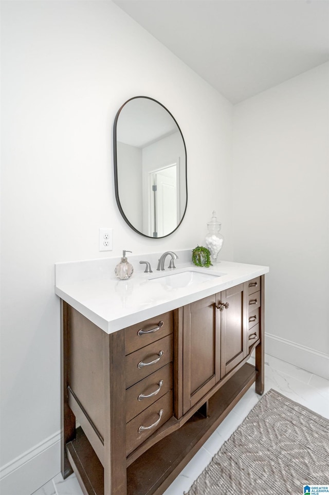 bathroom featuring baseboards, marble finish floor, and vanity