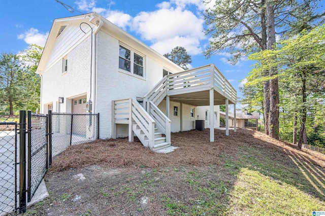 back of house with stairway, fence, a gate, and a garage