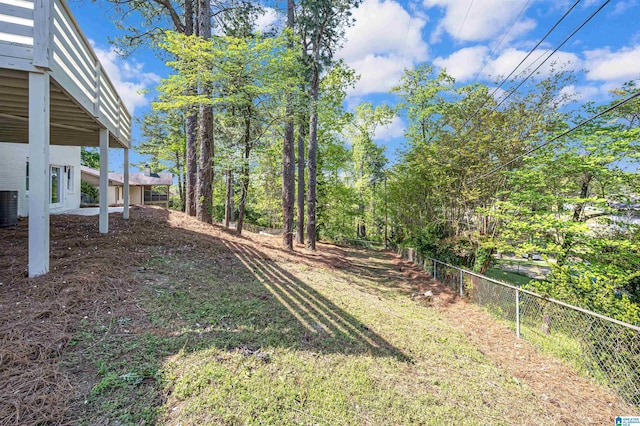 view of yard with central AC and fence