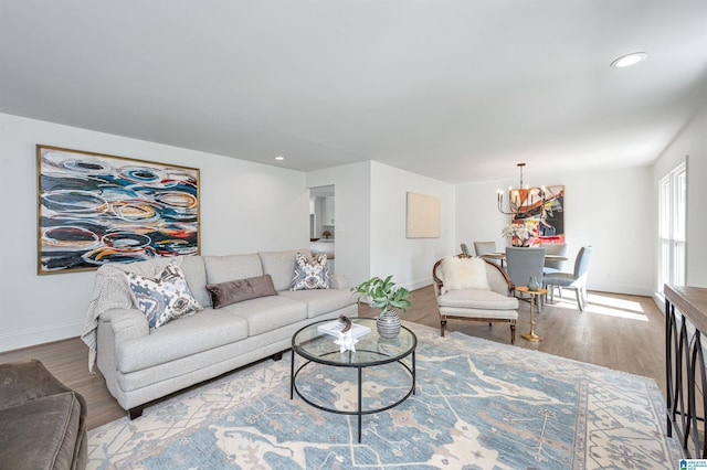 living room with wood finished floors, a notable chandelier, baseboards, and recessed lighting