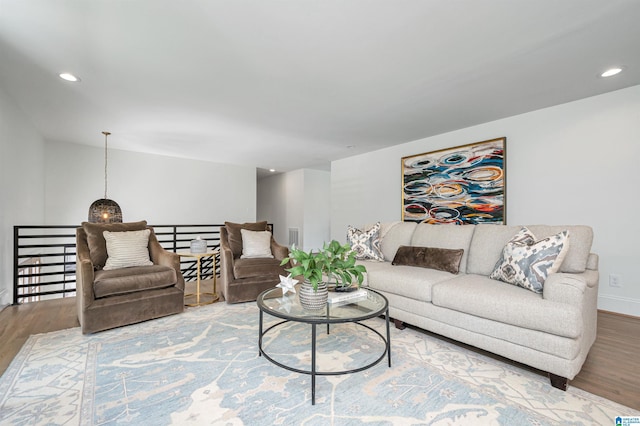 living room with visible vents, baseboards, recessed lighting, and wood finished floors