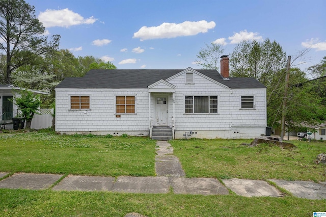 view of front of house featuring crawl space, a chimney, a shingled roof, and a front lawn
