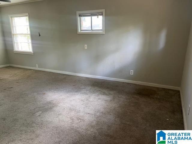 carpeted empty room featuring plenty of natural light and baseboards