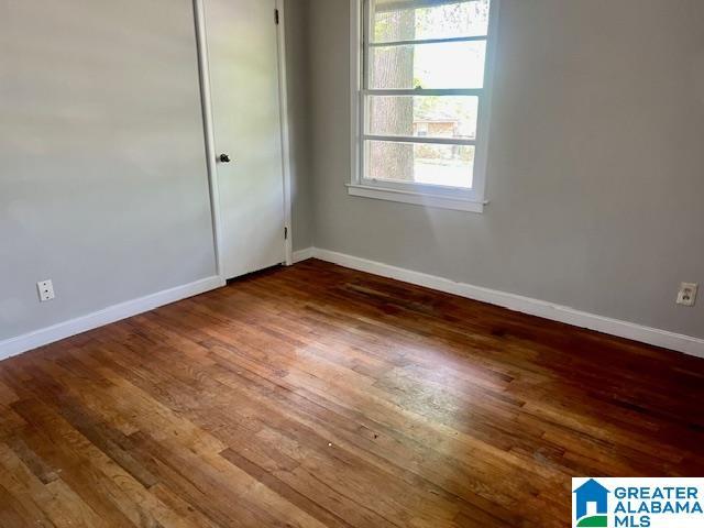 empty room with baseboards and wood finished floors