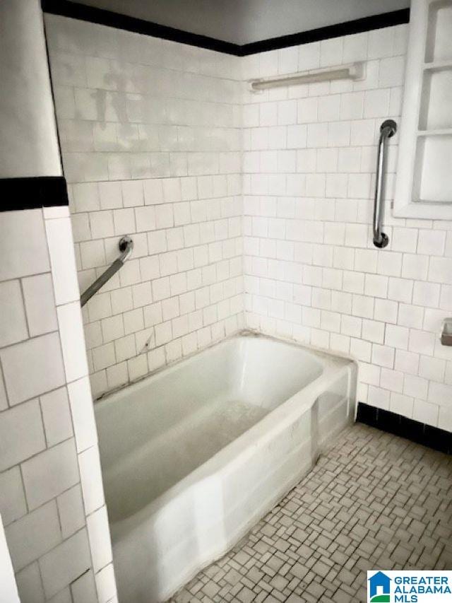full bath with tile patterned floors and tile walls