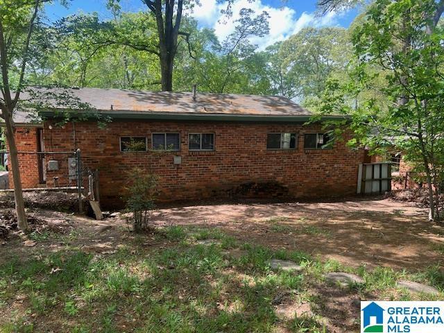 rear view of property with fence and brick siding