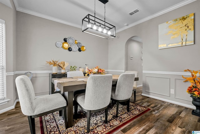 5544 Colony Ln, Hoover, AL 35226 - dining space with dark wood finished floors, arched walkways, ornamental molding, visible vents, and a wainscoted wall