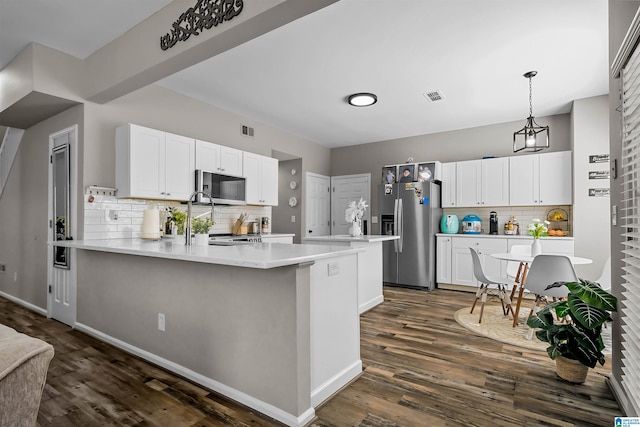 5544 Colony Ln, Hoover, AL 35226 - kitchen with dark wood finished floors, a peninsula, white cabinets, visible vents, and appliances with stainless steel finishes