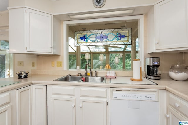 kitchen with tasteful backsplash, light countertops, white cabinets, white dishwasher, and a sink
