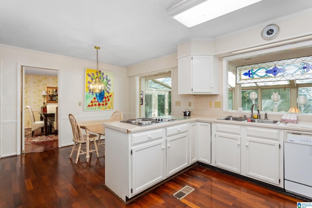 kitchen featuring a peninsula, visible vents, dark wood-style flooring, a sink, and white dishwasher