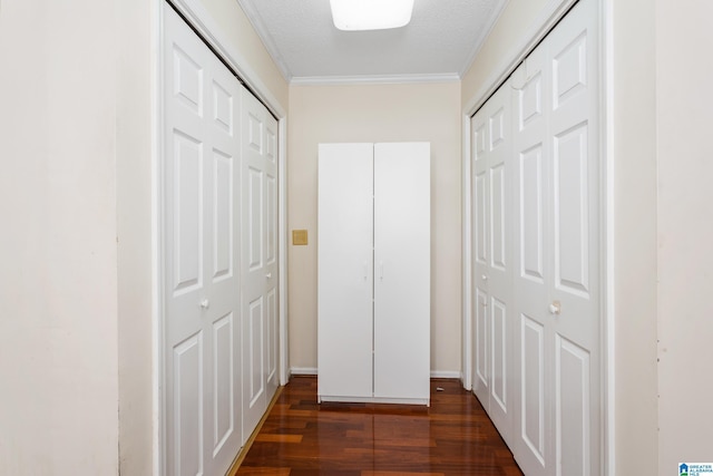 hall with dark wood-style flooring, crown molding, and a textured ceiling