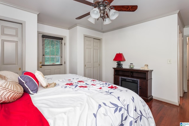 bedroom with a closet, a ceiling fan, a fireplace, crown molding, and wood finished floors