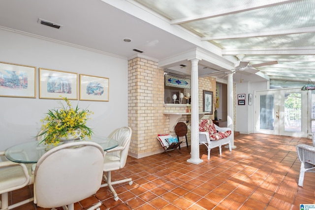 dining area featuring brick wall, visible vents, ornate columns, and french doors